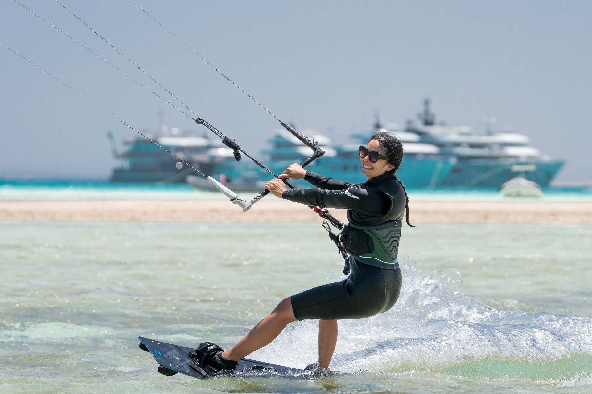 Kitesurfer riding past superyachts on the Red Sea