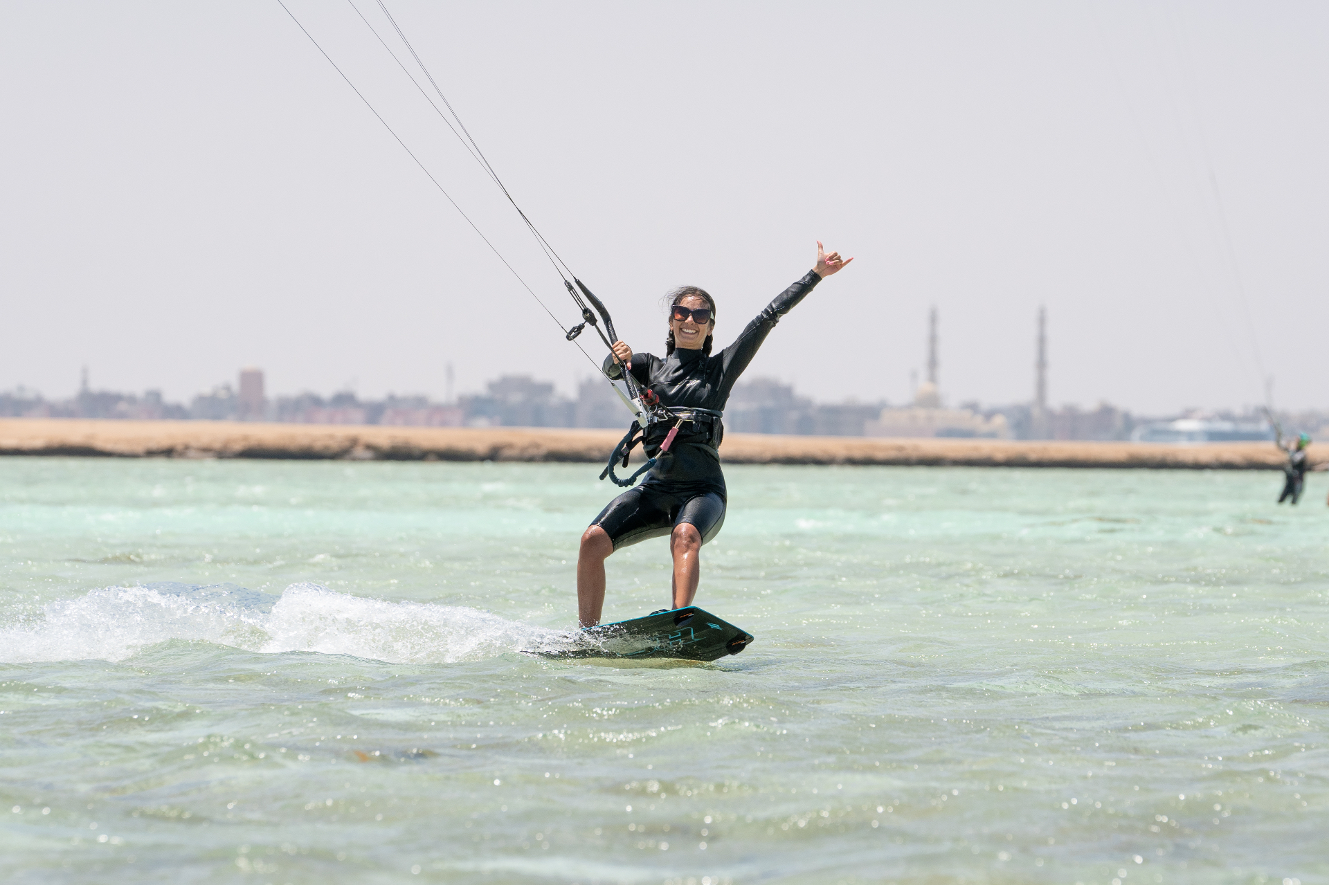 Smiling rider throwing a shaka on flat Red Sea water