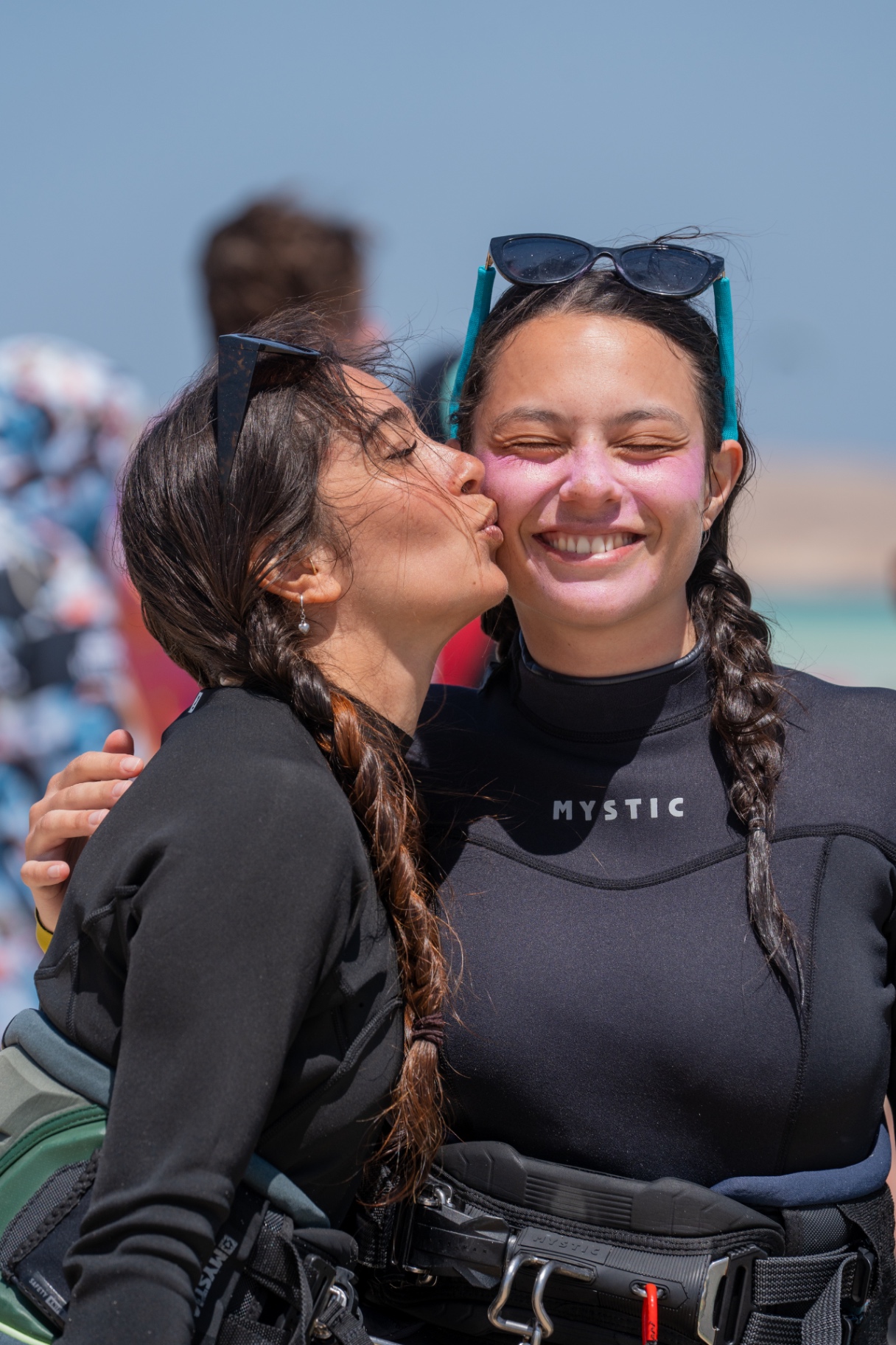 Two friends smiling and hugging after a kite session