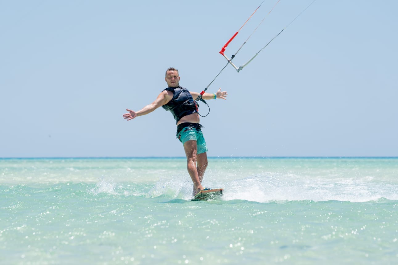 Kitesurfer riding relaxed with arms wide open