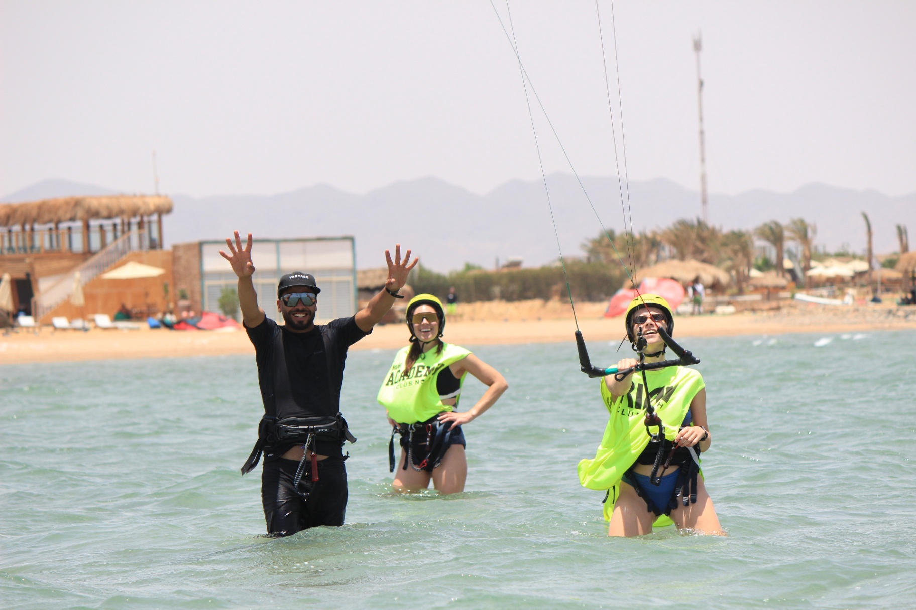 Kitesurf instructor celebrating with students in the water