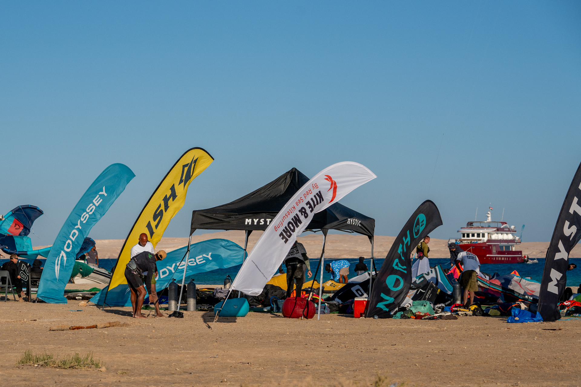 Kite & More safari beach setup with branded flags and a boat on the Red Sea
