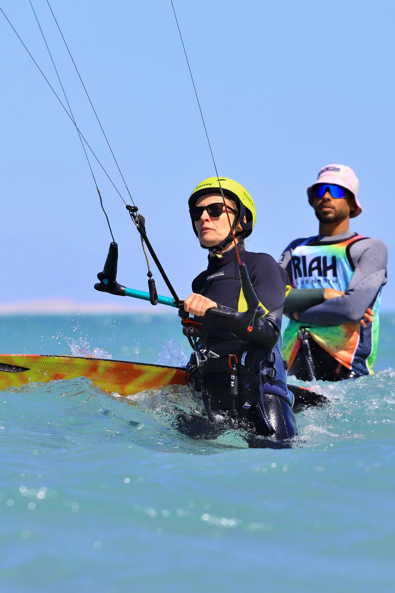 Student riding while instructor watches from behind