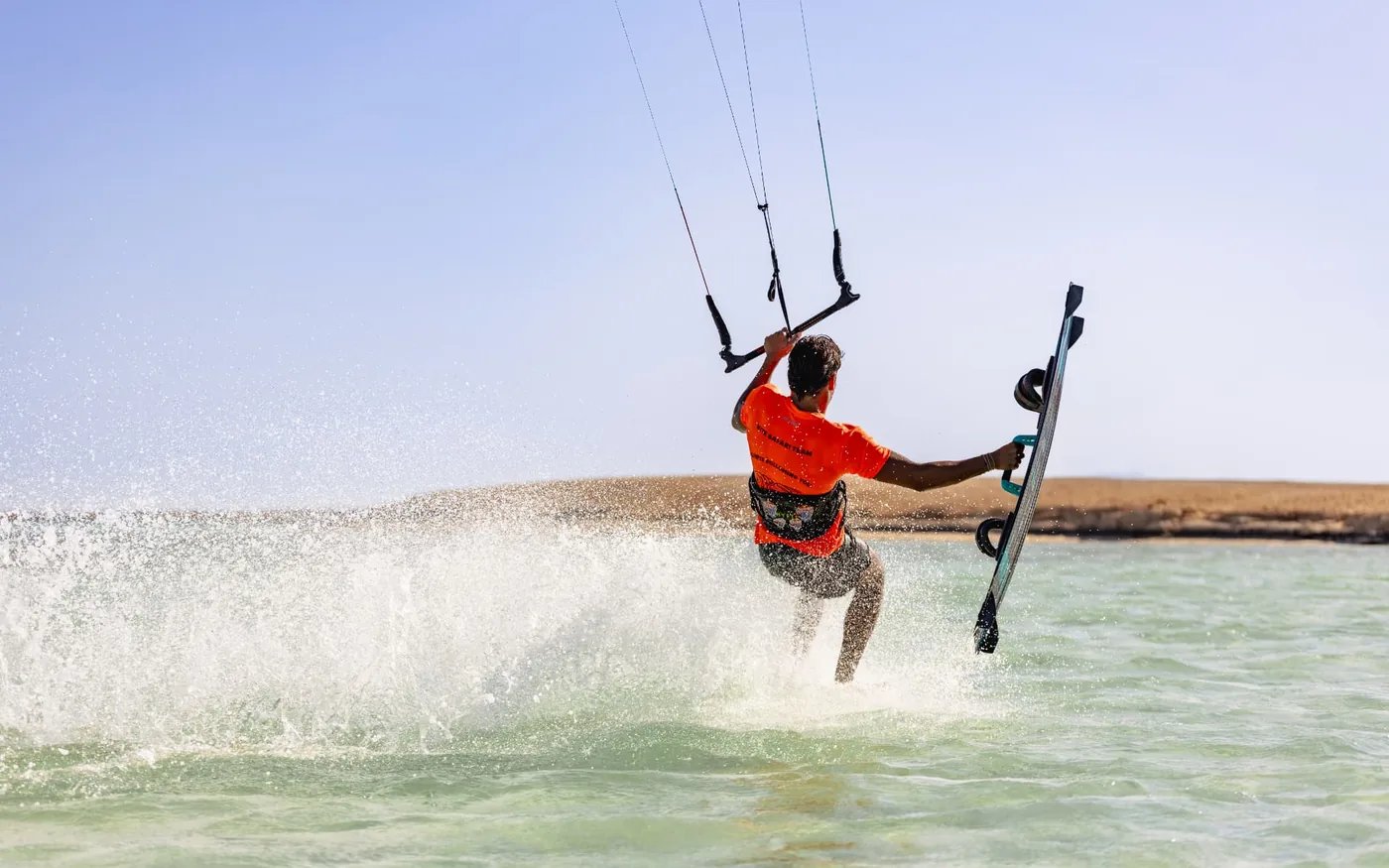 Kitesurfer sending up spray in the shallow water off Umm al Haymat island