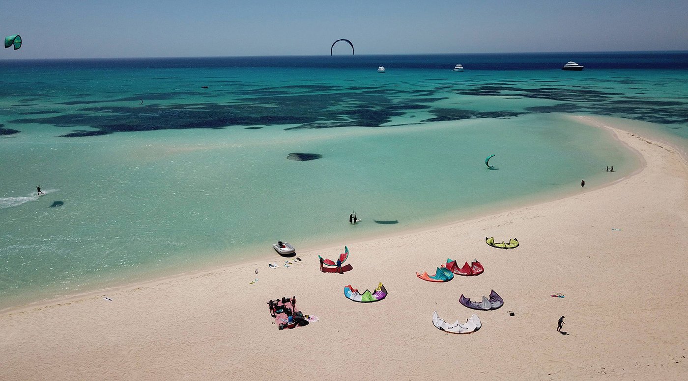 Aerial view of Tawila Island with turquoise shallow water, sandbanks, kites and kitesurfers